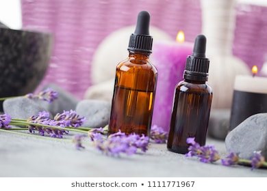 bottle of aromatherapy lavender oil with lavender flowers - beauty treatment
