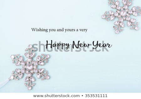 Happy New Year Background with snowflake ornaments on pale blue wood with sample text greeting. 