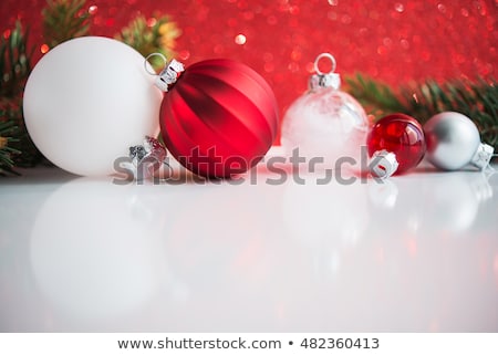 Red and white xmas ornaments on white and red glitter bokeh background. Merry christmas card. Winter holiday theme. Happy New Year. Space for text.