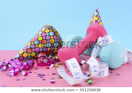 New Year Exercise Resolution with dumbbells and party decorations on white and blue background. 