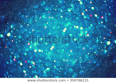 Christmas Blue Background. Glowing Holiday Abstract Defocused Background With Snowflakes and Stars. Blurred Bokeh